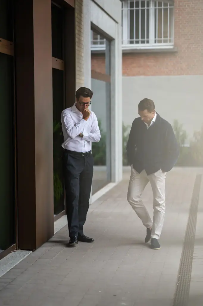 Twee mannen in business casual wandelen voor een winkelpand